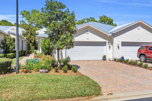 view of front of property featuring decorative driveway and a garage