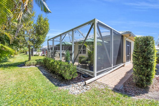 exterior space featuring a yard and glass enclosure