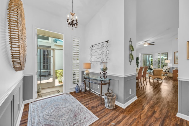 entrance foyer with a decorative wall, a high ceiling, dark wood-style floors, and a wainscoted wall