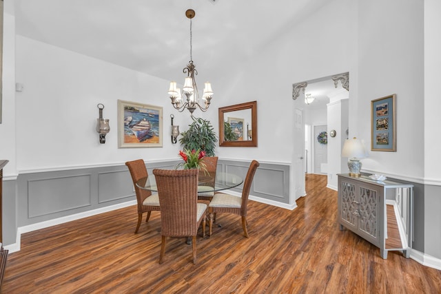 dining room featuring a notable chandelier, wood finished floors, and a decorative wall