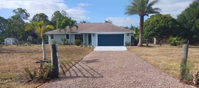 ranch-style house with a front yard, a garage, fence, concrete driveway, and stucco siding