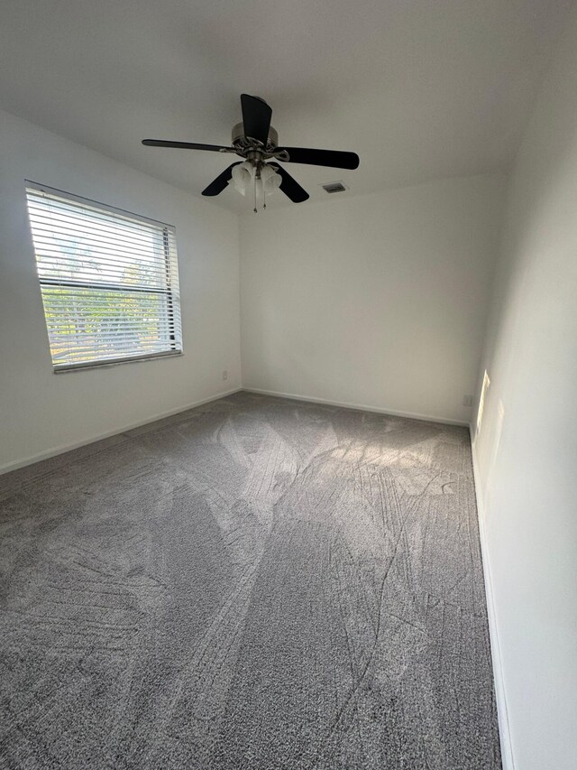 spare room with baseboards, carpet, a ceiling fan, and visible vents