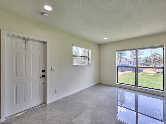 foyer with light tile patterned floors and a textured ceiling