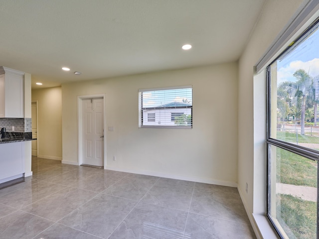 unfurnished room with light tile patterned floors, baseboards, and recessed lighting