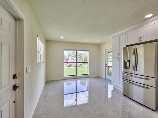 kitchen with recessed lighting, a textured ceiling, light tile patterned flooring, and stainless steel fridge with ice dispenser