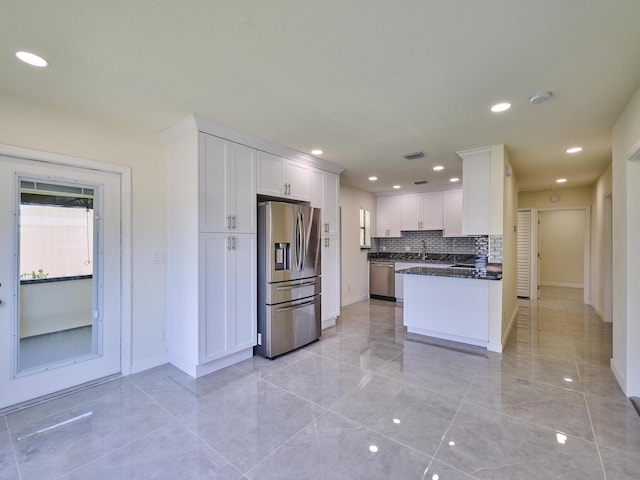kitchen with baseboards, white cabinets, and stainless steel appliances