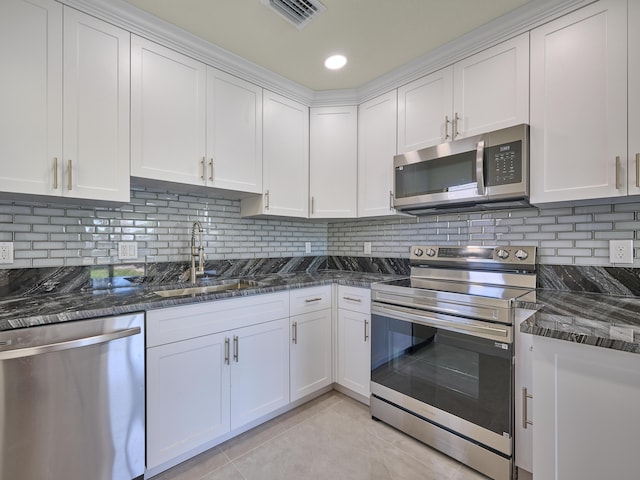 kitchen featuring visible vents, white cabinetry, a sink, appliances with stainless steel finishes, and light tile patterned floors