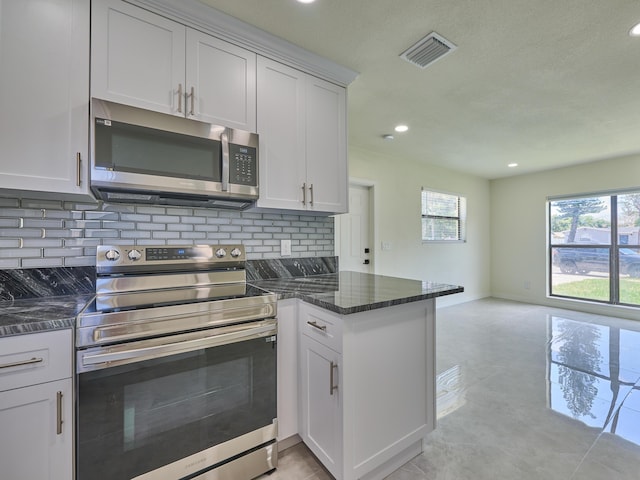 kitchen featuring white cabinets, backsplash, stainless steel appliances, and a peninsula