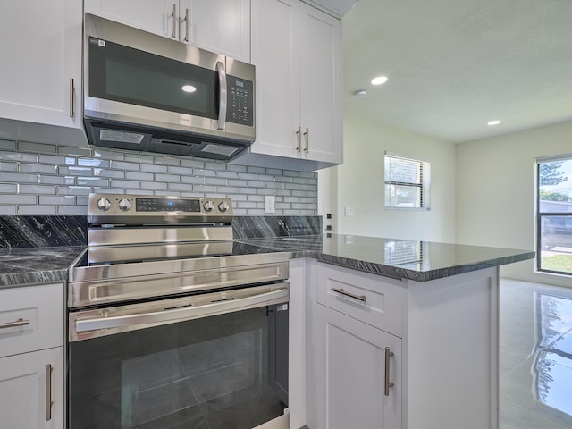 kitchen with white cabinets, a peninsula, and appliances with stainless steel finishes