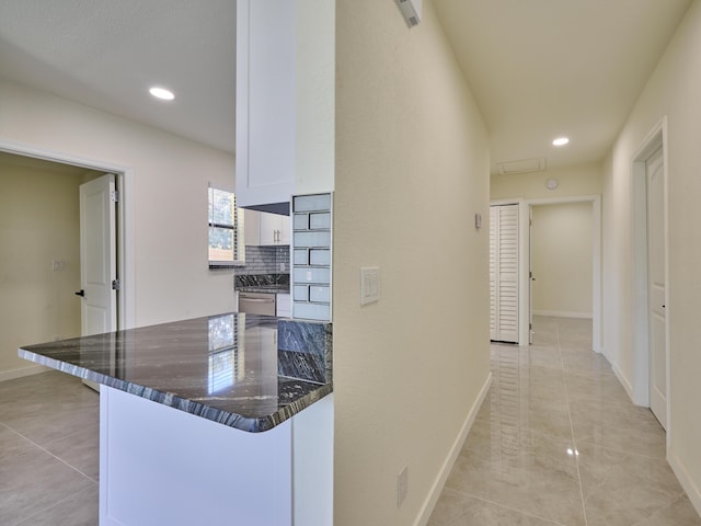 hallway featuring recessed lighting, baseboards, and light tile patterned floors