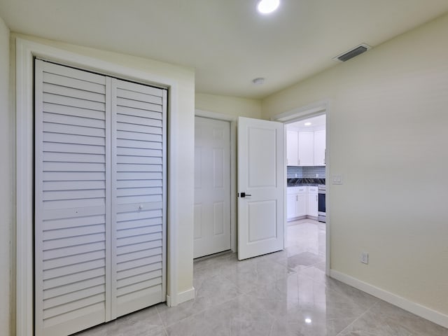unfurnished bedroom with baseboards, visible vents, and a closet