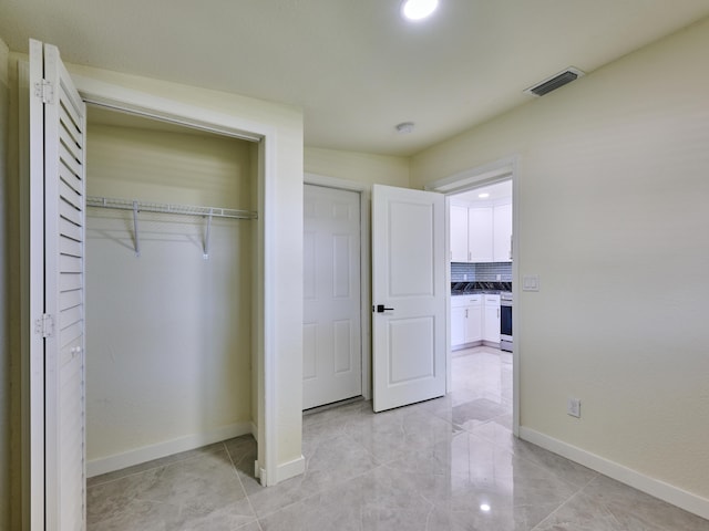 unfurnished bedroom with baseboards, a closet, and visible vents