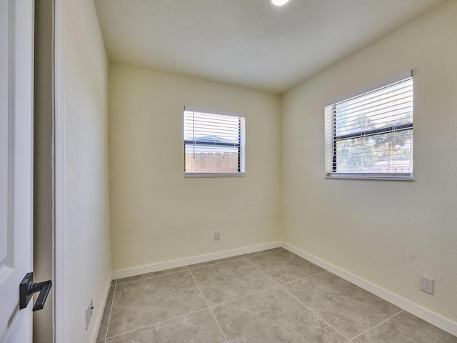 unfurnished room featuring light tile patterned floors and baseboards