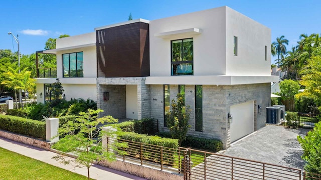 5288 Alton Rd Share B, Unit Share B, Miami Beach, FL 33140 - modern home with central air condition unit, fence, an attached garage, stone siding, and stucco siding