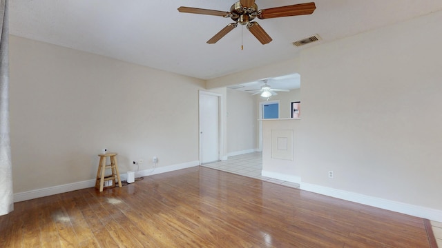 spare room featuring visible vents, baseboards, ceiling fan, and light wood-type flooring