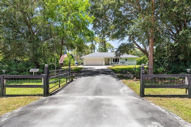 17109 81st Ln N, Loxahatchee, FL 33470 - single story home featuring an attached garage, a fenced front yard, a front yard, and aphalt driveway
