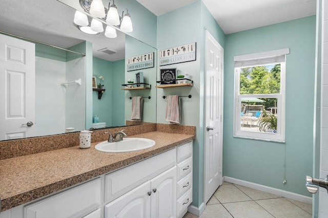 17109 81st Ln N, Loxahatchee, FL 33470 - bathroom with tile patterned flooring, vanity, baseboards, visible vents, and tiled shower