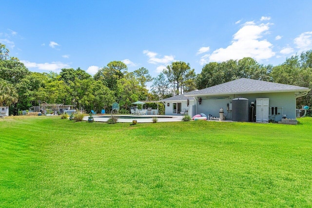 17109 81st Ln N, Loxahatchee, FL 33470 - back of house featuring a lawn, a patio area, roof with shingles, and an outdoor pool