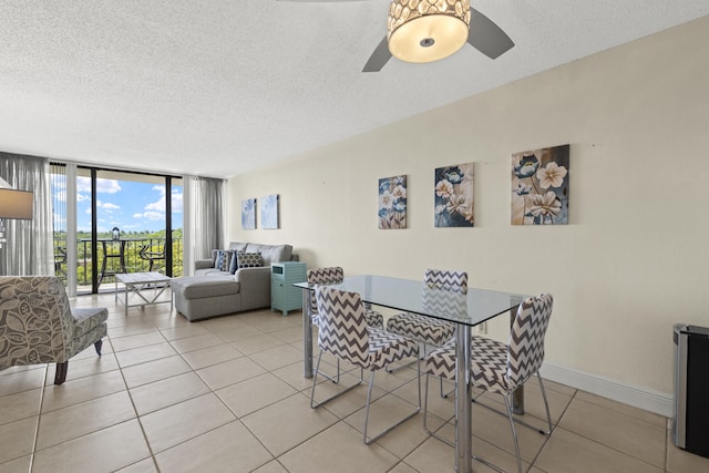 tiled dining room featuring baseboards, ceiling fan, floor to ceiling windows, and a textured ceiling