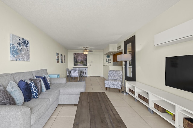 living room featuring light tile patterned floors, ceiling fan, and a textured ceiling
