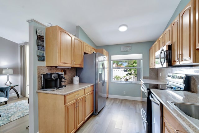 3516 Westminster Dr, Greenacres, FL 33463 - kitchen with appliances with stainless steel finishes, light wood-type flooring, decorative backsplash, and vaulted ceiling