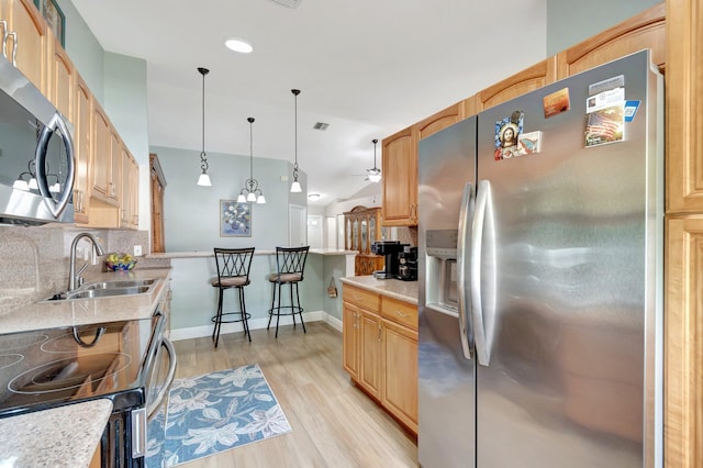 3516 Westminster Dr, Greenacres, FL 33463 - kitchen with appliances with stainless steel finishes, a sink, decorative backsplash, light wood-type flooring, and light countertops