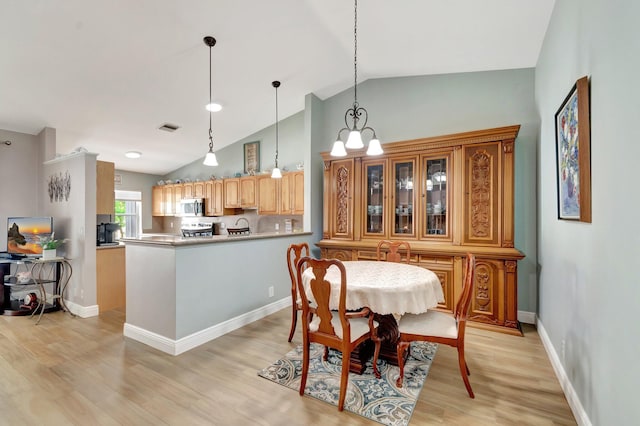 3516 Westminster Dr, Greenacres, FL 33463 - dining area featuring light wood-style flooring, vaulted ceiling, and baseboards