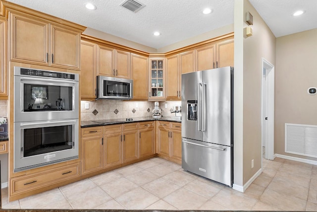 6616 NW 56th Dr, Coral Springs, FL 33067 - kitchen featuring appliances with stainless steel finishes, decorative backsplash, glass insert cabinets, baseboards, and light tile patterned floors