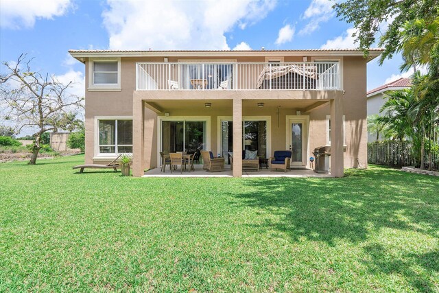 6616 NW 56th Dr, Coral Springs, FL 33067 - rear view of house featuring a balcony, stucco siding, a patio, and a yard