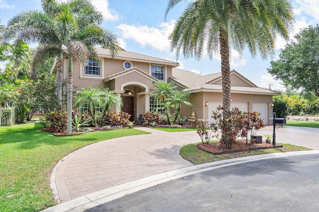 6616 NW 56th Dr, Coral Springs, FL 33067 - mediterranean / spanish-style home featuring curved driveway, stucco siding, a front lawn, and an attached garage