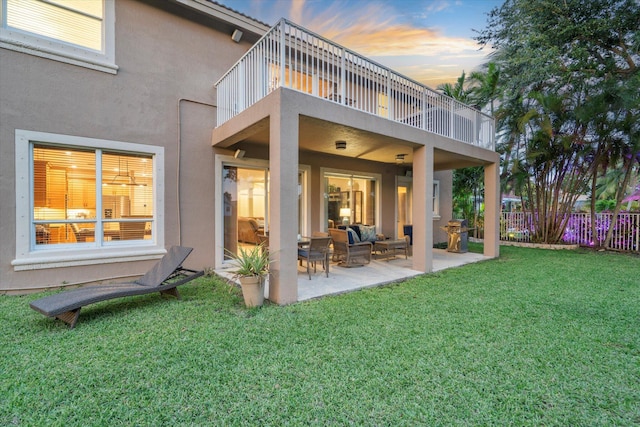 6616 NW 56th Dr, Coral Springs, FL 33067 - back of property at dusk with a balcony, stucco siding, an outdoor living space, and a patio
