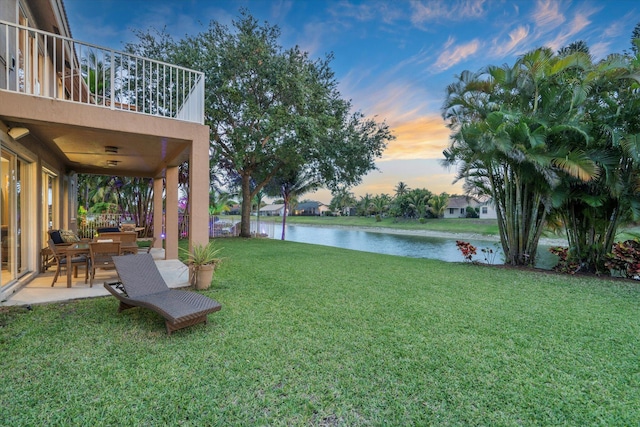 6616 NW 56th Dr, Coral Springs, FL 33067 - yard at dusk with a water view, a balcony, a patio, and a yard
