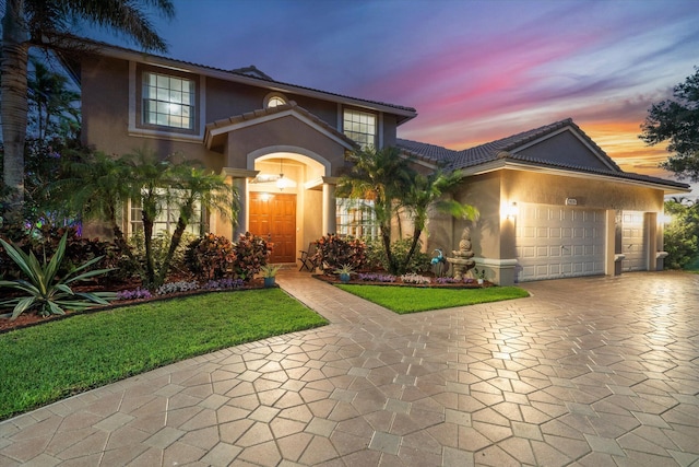 6616 NW 56th Dr, Coral Springs, FL 33067 - view of front facade featuring stucco siding, decorative driveway, an attached garage, a tile roof, and a yard