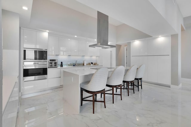 20155 Boca W Dr Unit Phc902, Boca Raton, FL 33434 - kitchen featuring appliances with stainless steel finishes, modern cabinets, island exhaust hood, white cabinets, and recessed lighting