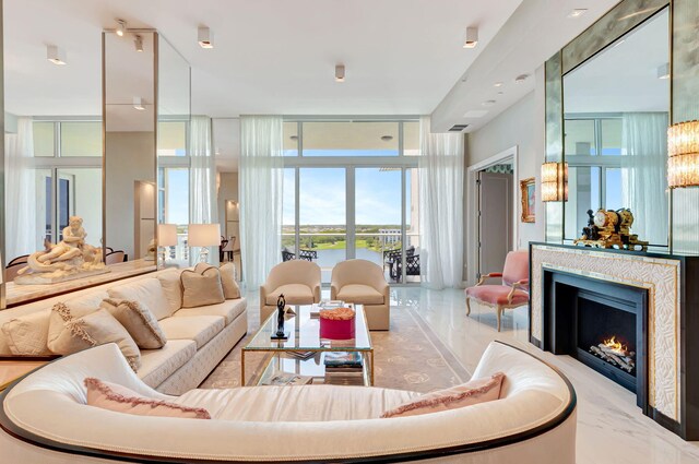 20155 Boca W Dr Unit Phc902, Boca Raton, FL 33434 - living room with a water view, expansive windows, marble tiled floors, and a warm lit fireplace