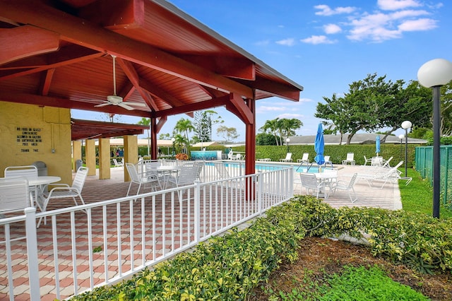 1150 Boxwood Dr Unit 203, Delray Beach, FL 33445 - view of patio / terrace featuring fence, a gazebo, ceiling fan, outdoor dining area, and a community pool