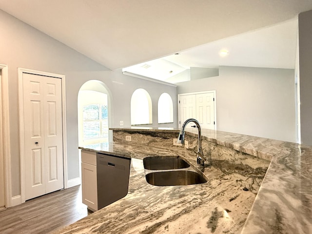 673 SW Granadeer St, Port Saint Lucie, FL 34983 - kitchen featuring a sink, light stone countertops, arched walkways, dishwasher, and lofted ceiling