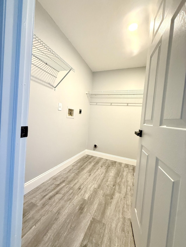 673 SW Granadeer St, Port Saint Lucie, FL 34983 - clothes washing area featuring wood finished floors, laundry area, hookup for an electric dryer, washer hookup, and baseboards