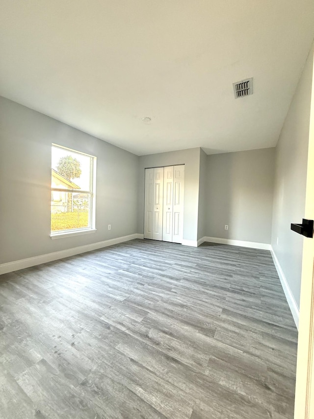 673 SW Granadeer St, Port Saint Lucie, FL 34983 - unfurnished bedroom featuring baseboards, a closet, visible vents, and wood finished floors