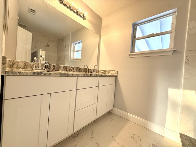 673 SW Granadeer St, Port Saint Lucie, FL 34983 - full bath with double vanity, a sink, visible vents, baseboards, and marble finish floor