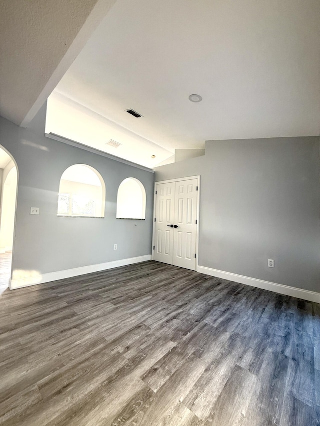 673 SW Granadeer St, Port Saint Lucie, FL 34983 - unfurnished room featuring arched walkways, dark wood-style flooring, baseboards, and visible vents