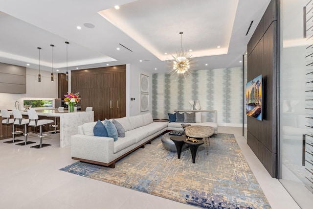living room with a tray ceiling, recessed lighting, and a chandelier