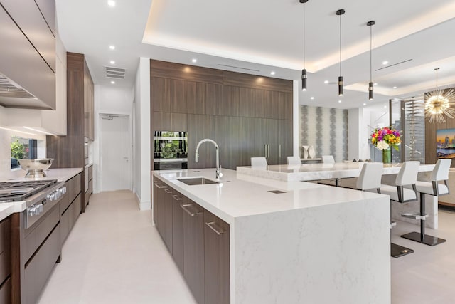 kitchen featuring modern cabinets, a sink, recessed lighting, stainless steel gas cooktop, and range hood