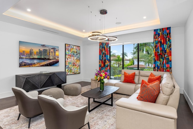 sitting room with a tray ceiling, baseboards, a chandelier, recessed lighting, and wood finished floors