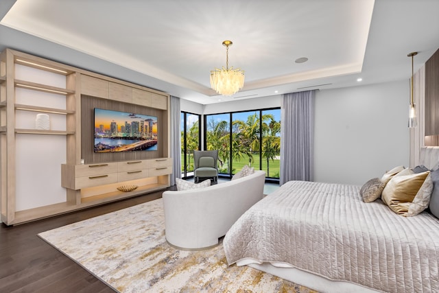 bedroom featuring a tray ceiling, a chandelier, wood finished floors, and recessed lighting