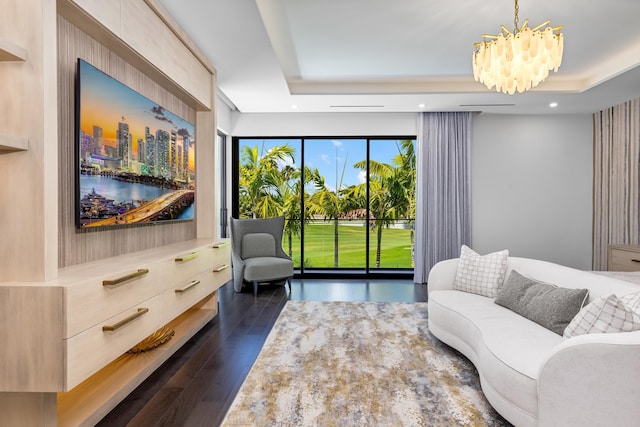 sitting room featuring a chandelier, dark wood-style flooring, a tray ceiling, and recessed lighting