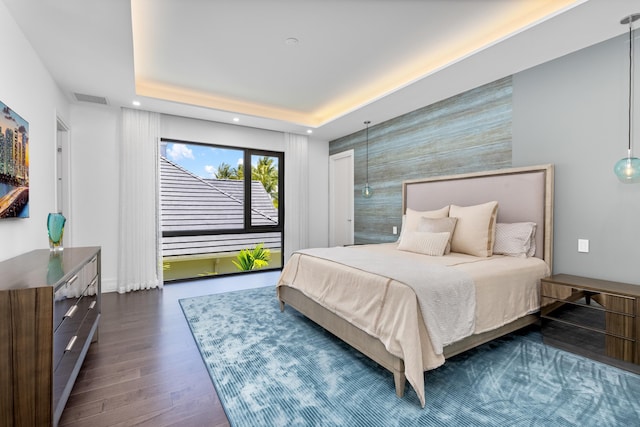 bedroom featuring dark wood-type flooring, an accent wall, and recessed lighting