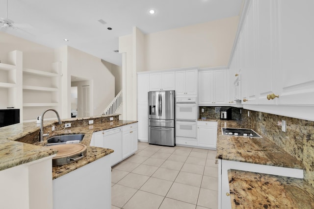 kitchen with white cabinets, light stone countertops, open shelves, a sink, and white appliances