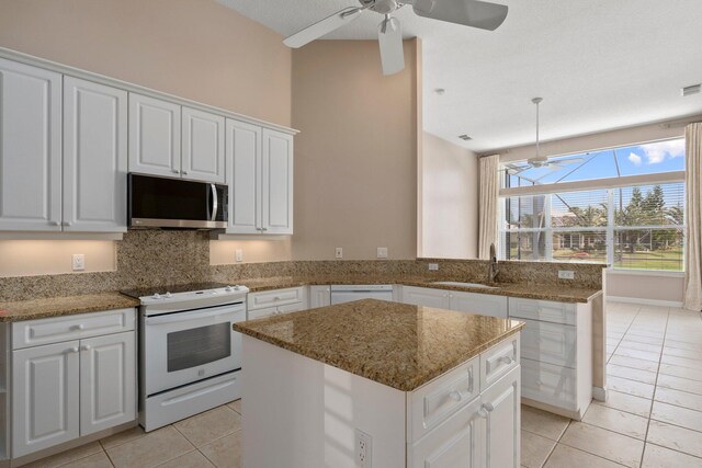 kitchen featuring a sink, ceiling fan, light tile patterned flooring, and white appliances