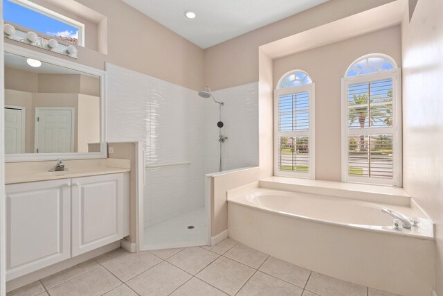 full bath with a garden tub, tile patterned floors, a tile shower, and vanity
